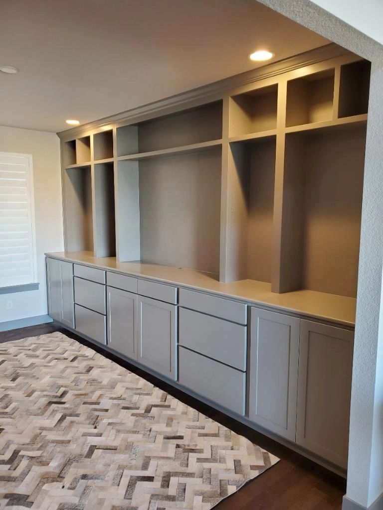 Grey built-in cabinet wall with a chevron rug in the foreground