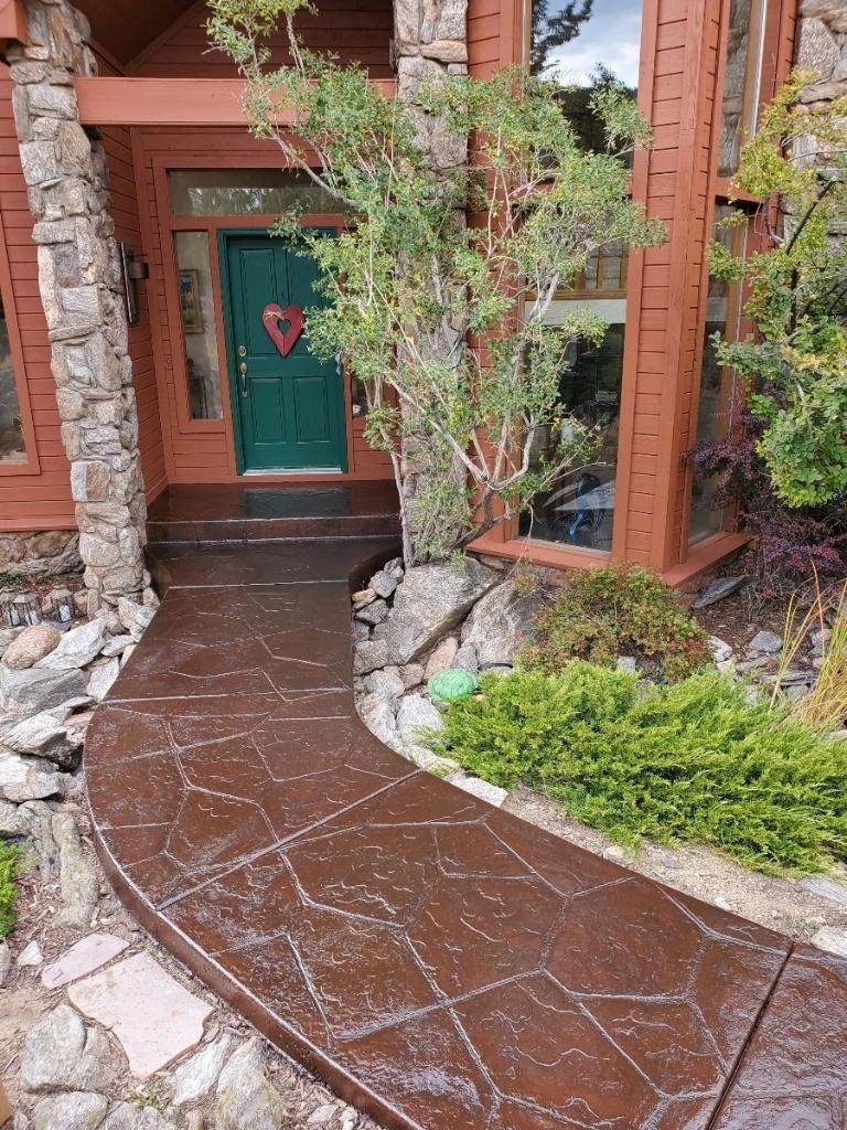 Front entry with rust-colored siding and a green door