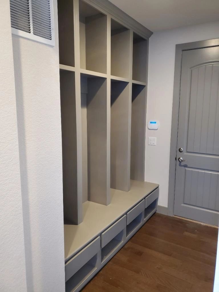 Grey painted mudroom cubbies and a matching door